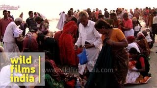 Indian pilgrims putting their clothes on after a holy dip [upl. by Htrowslle]